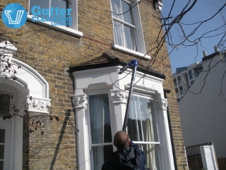 Experienced gutter cleaner in action in London